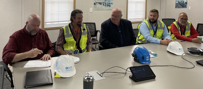 Matthew Thurlby, Area Director, Omaha Area Office, US DOL-OSHA, with representatives from Nebraska On-Site Consultation and Holder Construction Goup, sign the Partnership agreement.