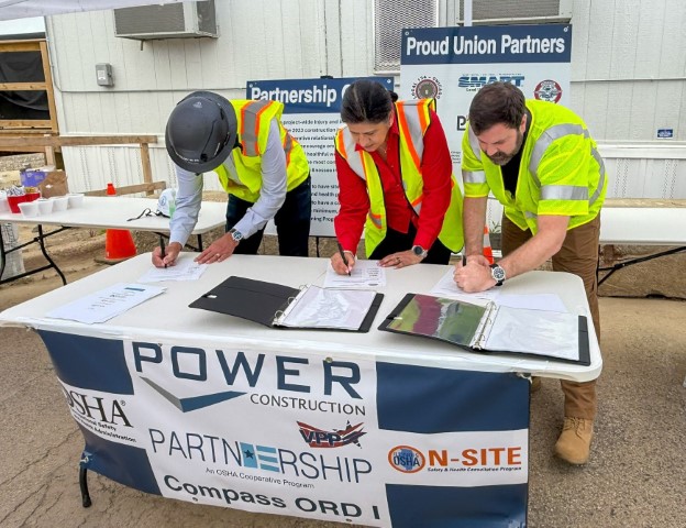 Sukhvir Kaur, Chicago North Area Office Director, OSHA; Eric Kambarian, Program Representative, Illinois On-Site Safety and Health Consultation; and Jeff Geier, President and CEO, Power Construction Company, sign the Partnership agreement.