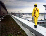 Worker walking on beam protected by a fall arrest system