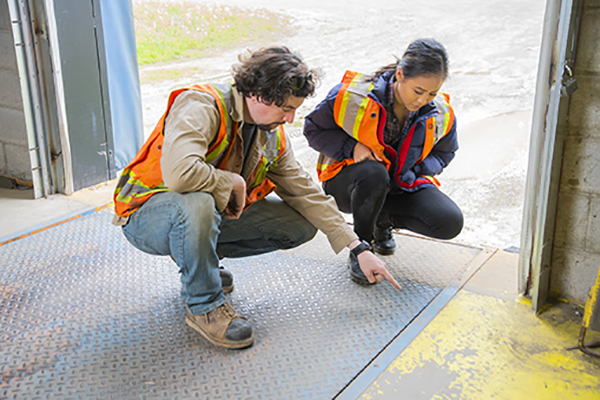 Two workers inspecting a hazard at a worksite