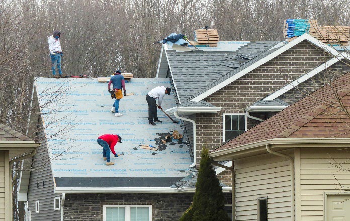 roofers working on roof of house