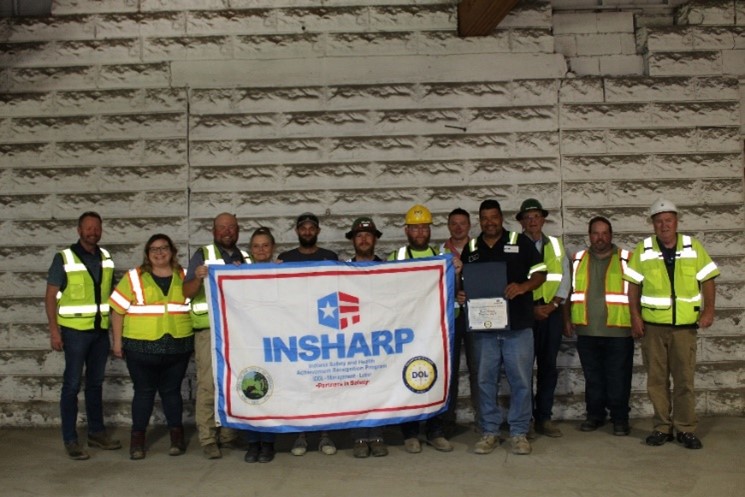New Albany River Metals employees standing with their SHARP flag