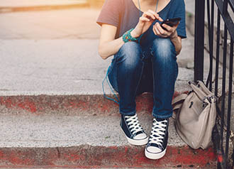 Additional Resources - Girl sitting on steps surfing on phone | copyright: martin-dm - istock.com:492279482