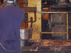 Fig. 4. Lifting recently cast lead blocks from mold