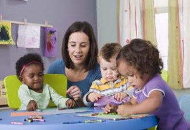 Photo of adjult with toddlers at a table coloring with crayons. | Photo Credit: DOL/Bureau of Labor Statistics