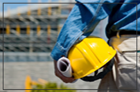 worker with hard hat looking at a building in the distance