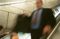 photograph of man quickly walking down stairs or an escalator