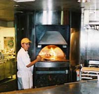 Image of a young worker working in front of a hot oven