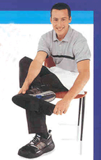 young worker sitting down, and putting non-slip "over" shoes on his sneakers.