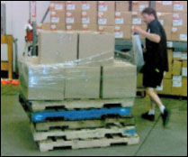 Figure 36. Elevating pallets reduces awkward postures when used for manual wrapping. Ensure pallets are secured and stacks are not above shoulder height.