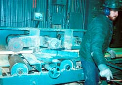 Infeed to planer. Note the unguarded pineapple roll and infeed roll.