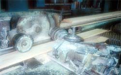 Board is fed into planer by pineapple and cylindrical infeed rolls.