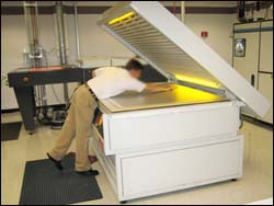 Figure 6. Forward bending and reaching over a “clam shell”-type plate processor can increase strain on a variety of muscles.