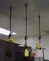 Electrical plugs hanging from a ceiling, tied-off for safety.
