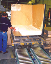 Figure 20. Using a pallet lift for stacking signatures. When full, the pallet is released and rolls down roll conveyor for pickup by forklift.