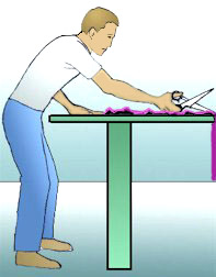 Fig. 2 Extended reach and bending over table causes ergonomic stress on back, shoulders, and arms.