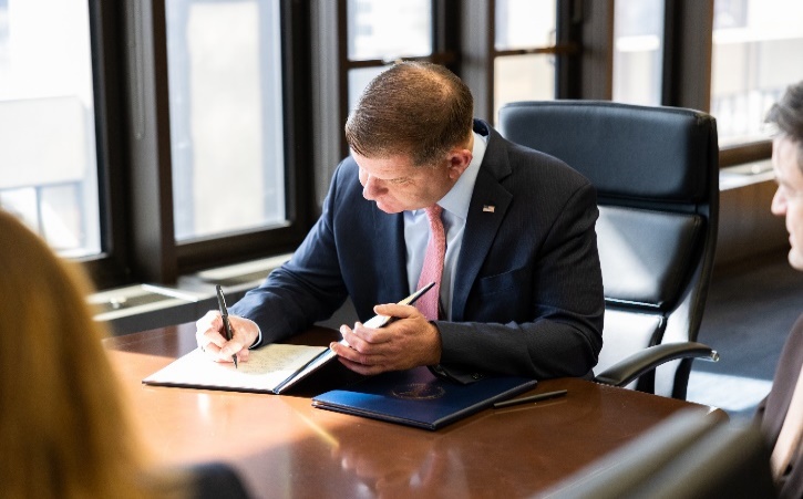 Secretary of Labor Marty Walsh signing a memorandum at the Department of Labor in Washington on Feb. 13, 2023.