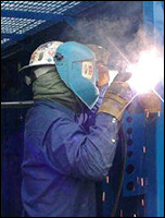 welder welding a joint on an upright