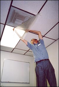 Person taping plastic sheeting over a vent to close airflow; Tape plastic sheeting over vents, windows, and doors to prevent contaminated air from entering the room