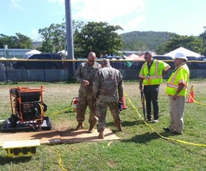 Team of consultants from Puerto Rico’s On-Site Consultation program (wearing high visibility vests) providing electrical safety recommendations to members of the National Guard in Guánica’s largest shelter.