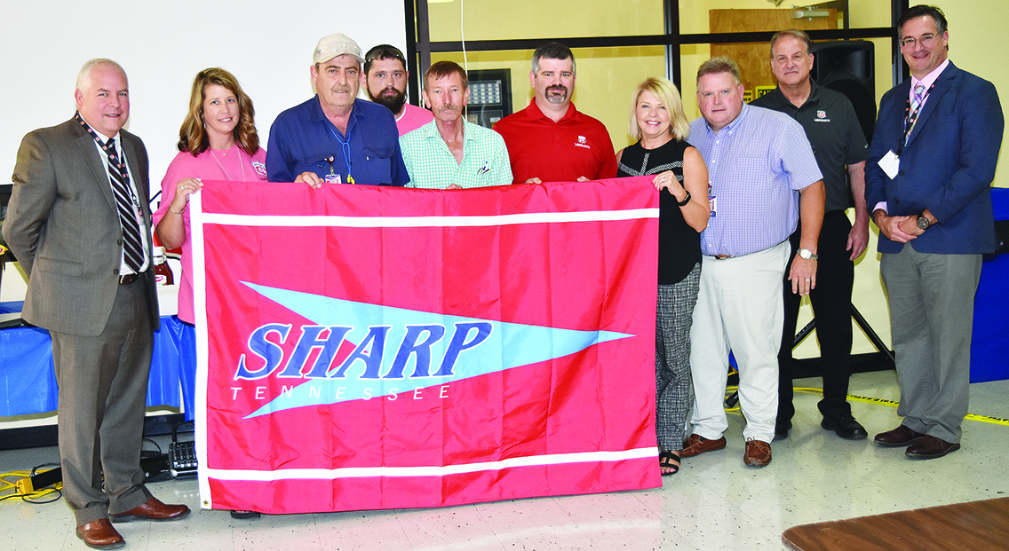 TOSHA Administrator Steve Hawkins (L) and TOSHA Consultative Services Program Manager Garrett Rea (R) present the TOSHA SHARP flag to the Safety Committee at Phillips 66 Spectrum Corporation