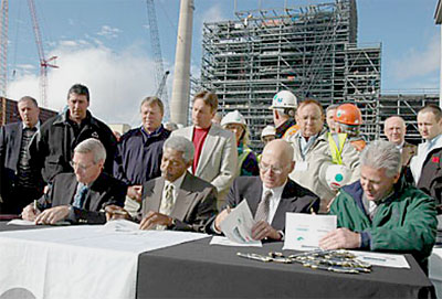 Four key representatives sign the OSHA Partnership Agreement on November 2, 2005. From left to right seated are: Charlie Schrock of Wisconsin Public Service Corporation, Greg Jones and Barry Glashagel from the State of Wisconsin’s Department of Commerce, and Howard Eberts from OSHA. Representatives from local trades, unions, contractors and other stakeholders also signed onto the agreement that signifies the commitment to worker safety in the building of the new Weston 4 Power Plant.