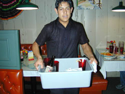 young worker bussing dishes from a table