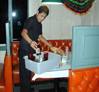 young worker bussing dishes in a basin container.