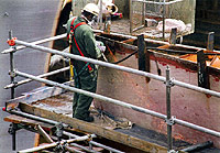 Figure 3: Worker grinding while protected by proper guardrail, mid-rail, and toeboard
