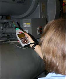 worker positioning a sound level meter.