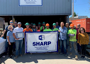Nucor Harris employees holding up SHARP flag.