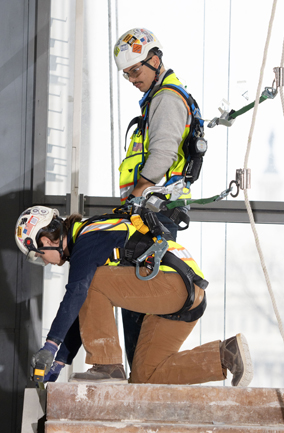 Workers wearing fall safety gear in construction site