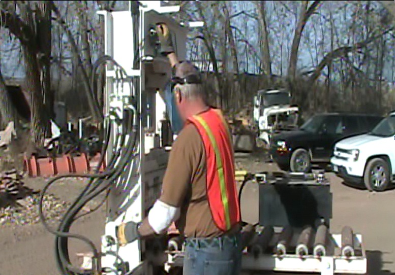 Operator using the retrofitted stone cutter while wearing appropriate protective clothing (hearing protection, gloves, and faceshield).